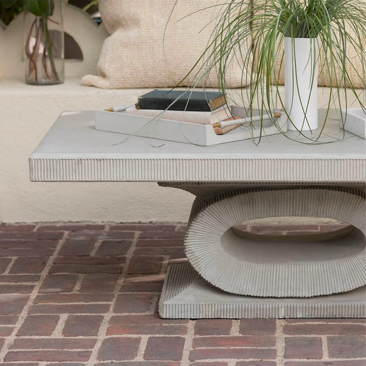Light grey leather tray on display in an outdoor patio coffee table with books and greenery.