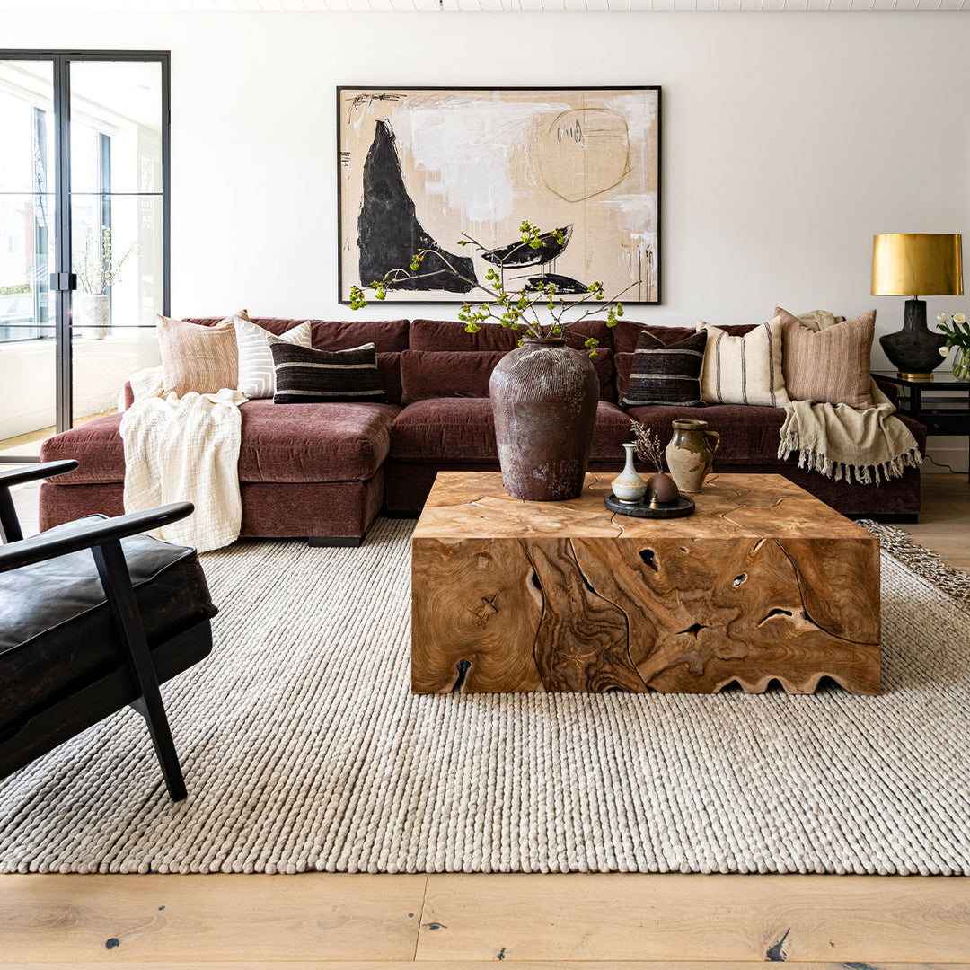 An earth-toned living room with natural decor elements and large abstract art print.