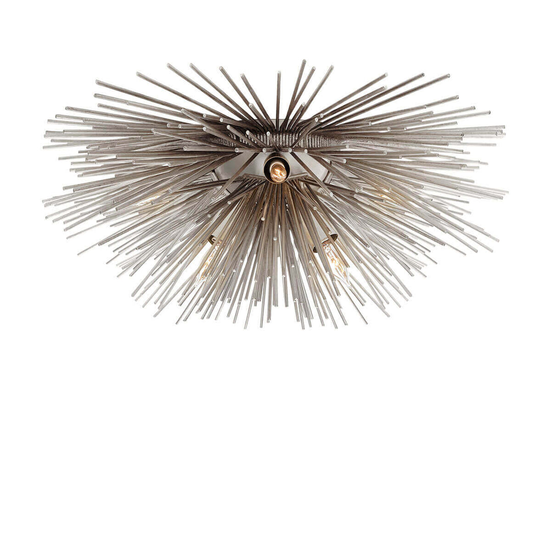 The Strada Flush Mount has twelve small lights amongst a burnished silver leaf starburst with metal spikes.