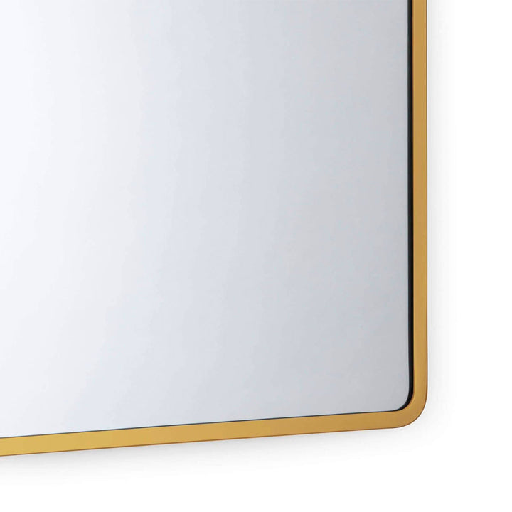 Modern, sleek edge of the Syros Mirror, finished in a natural brass colour.