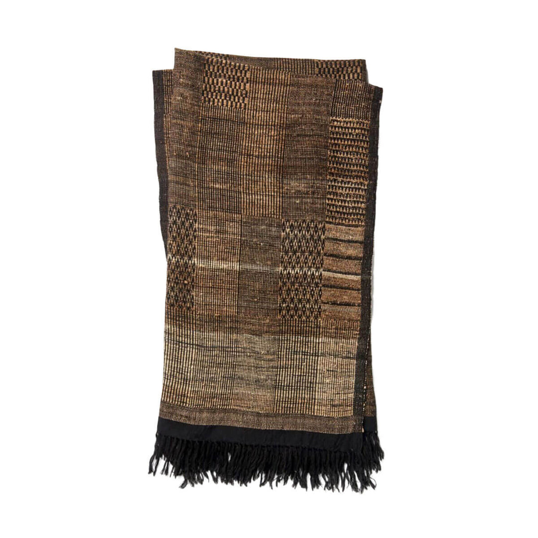 The Tejada Throw - Beige / Black is a wool and silk blend throw blanket with a black and beige tribal pattern.
