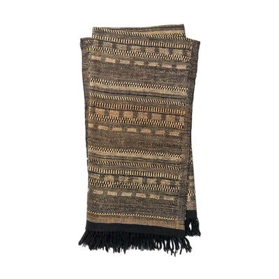 The Tejada Throw - Black / Beige is a luxurious, wool and silk blend throw blanket with a black and beige ancient tribal pattern.