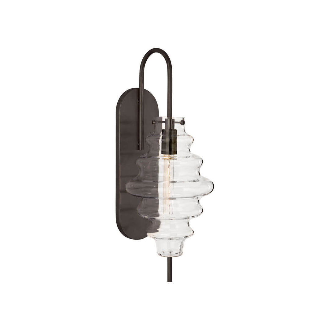 The Tableau Wall Sconce has a bronze backplate and hooked arm with a clear glass rippled lamp shade.