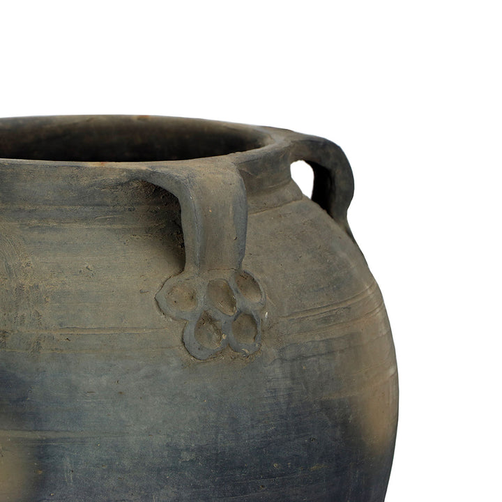 Close up image of hand crafted, antique details on the handles of this water pot.