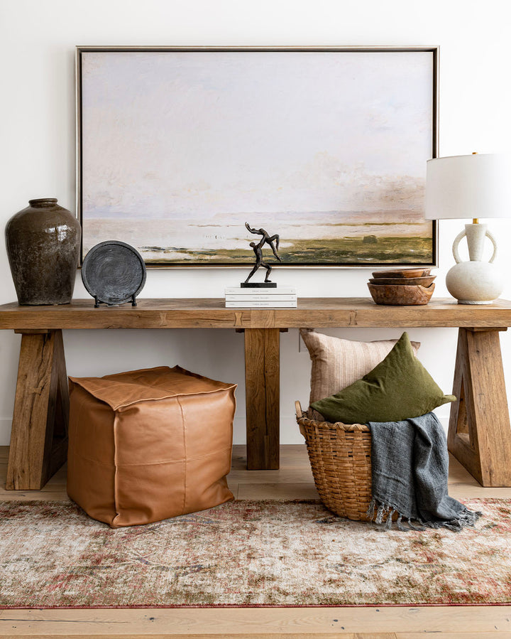 Coastal art above console table with vintage, earthy accessories.