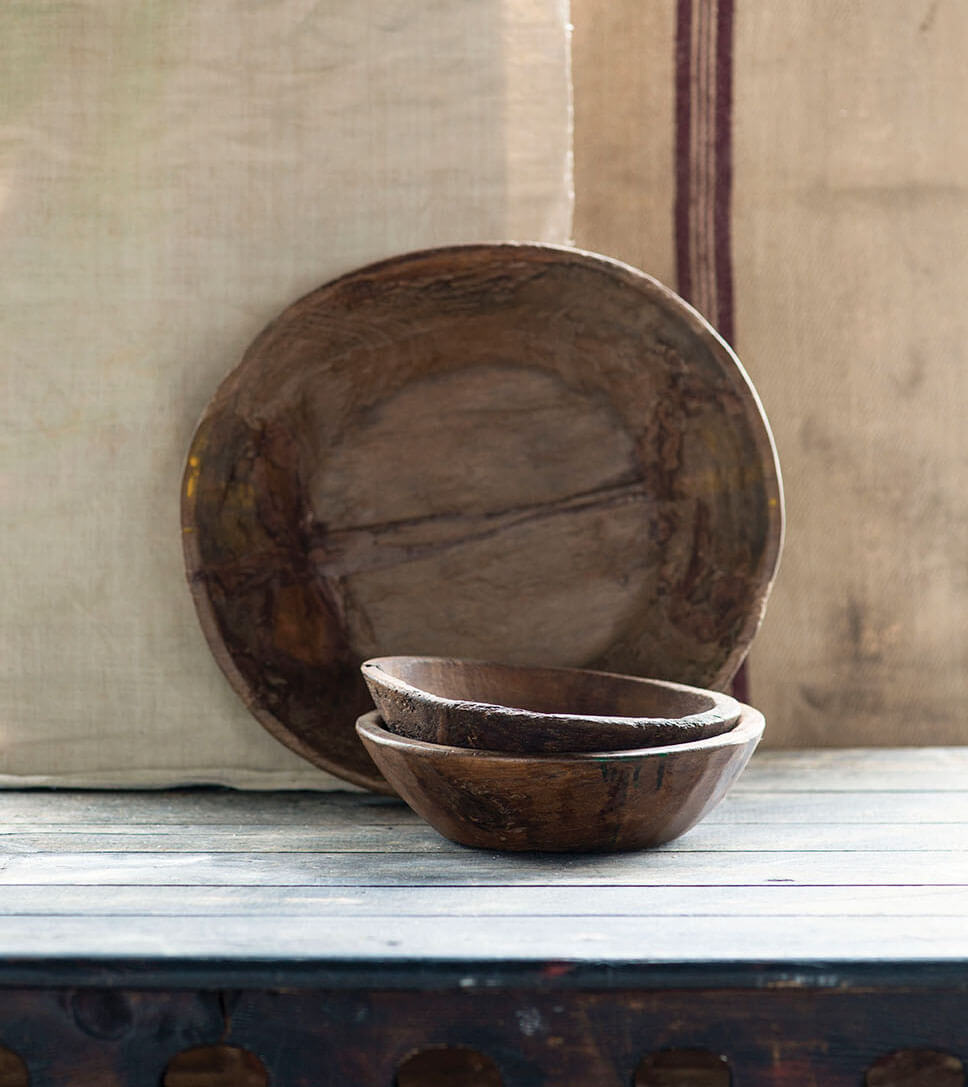 Teak wood bowls in various sizes on a shelf.