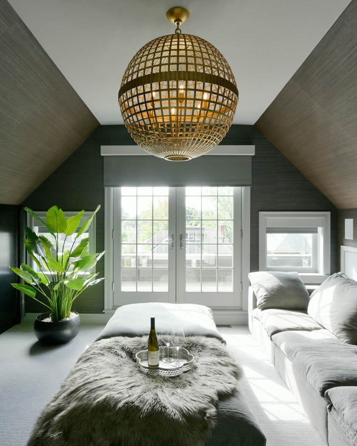 Lifestyle shot of the Mill Globe Lantern, a large gild pendant light with a globe shade and a chain hanger.