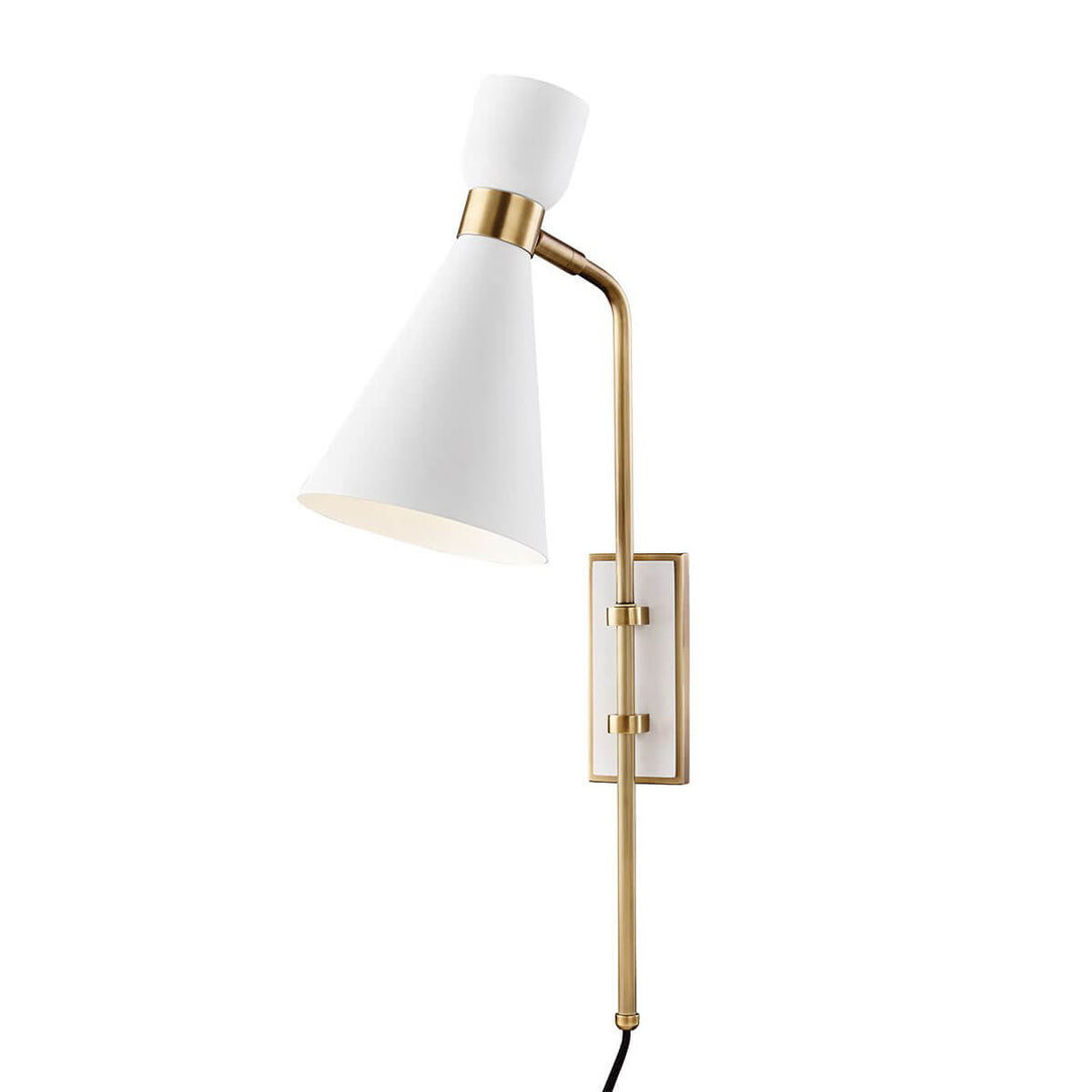 The Hudson Wall Sconce with a white tapered lamp shade and brass cuff details.