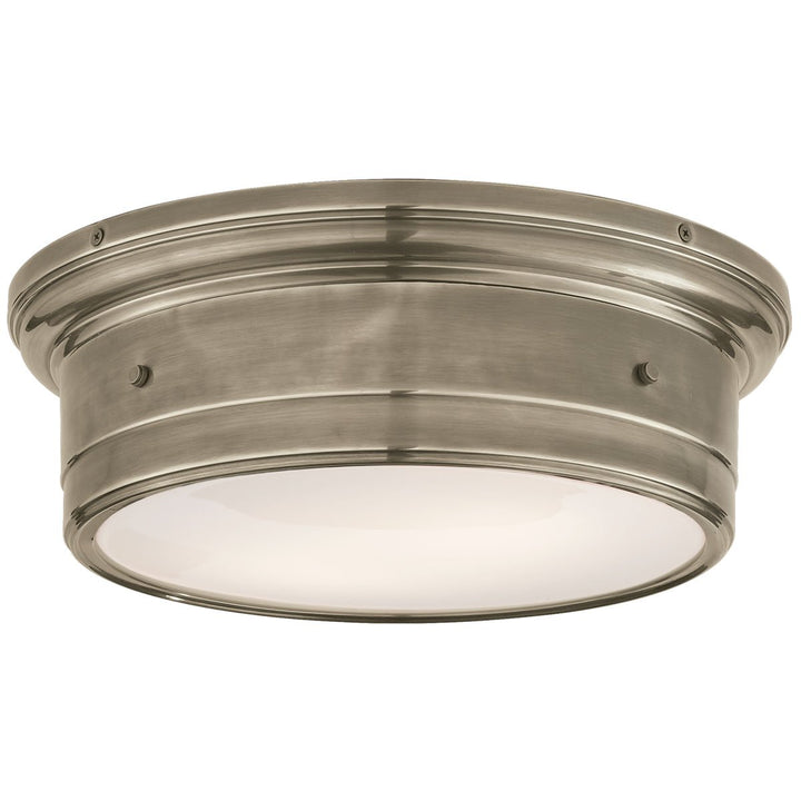 The Siena Flush Mount in Large has a simple drum shape in antique Nickel finish with covered bolt details and a white glass diffuser.