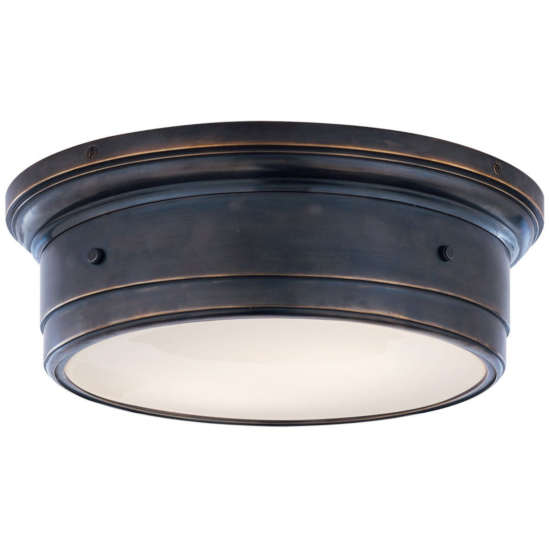 The Siena Flush Mount in Large has a simple drum shape in bronze  finish with covered bolt details and a white glass diffuser.